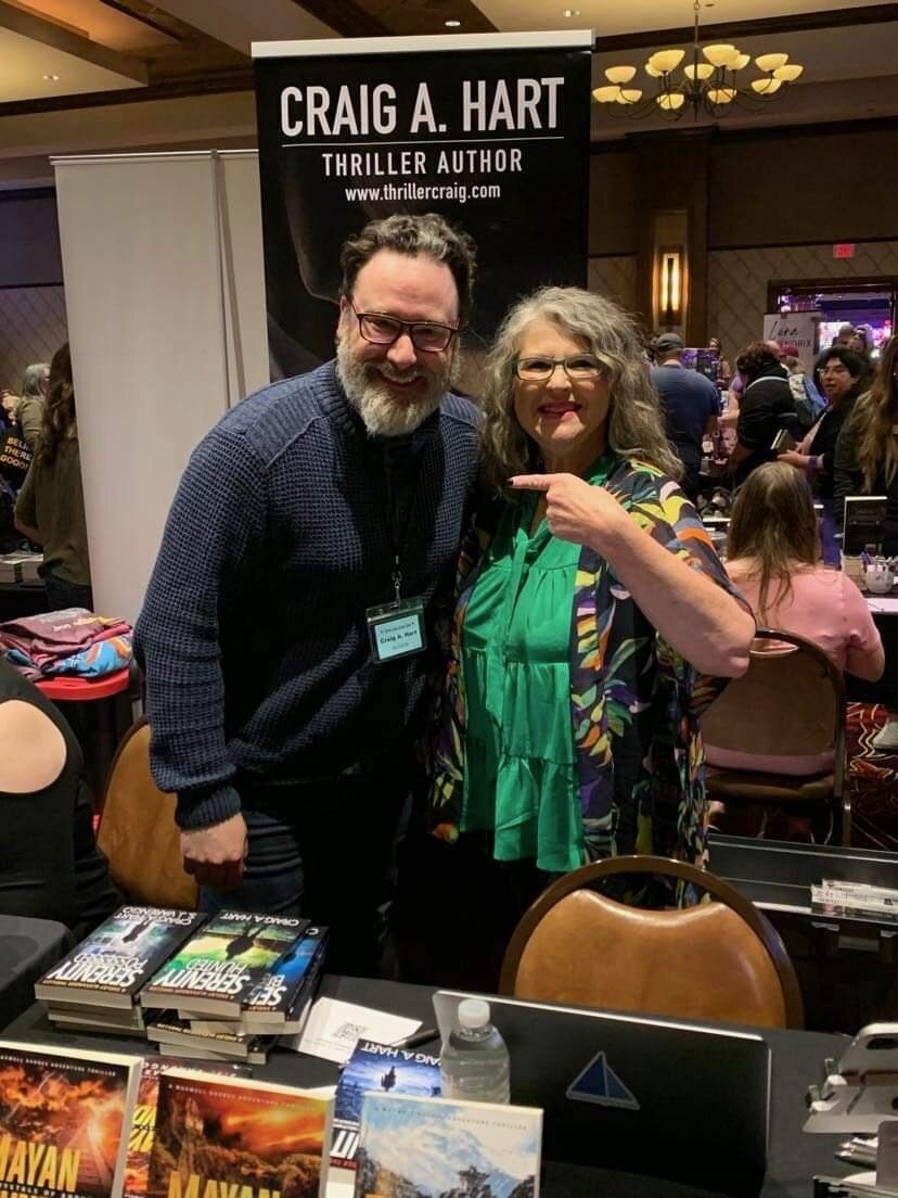 Craig A. Hart smiling with a reader at a book signing