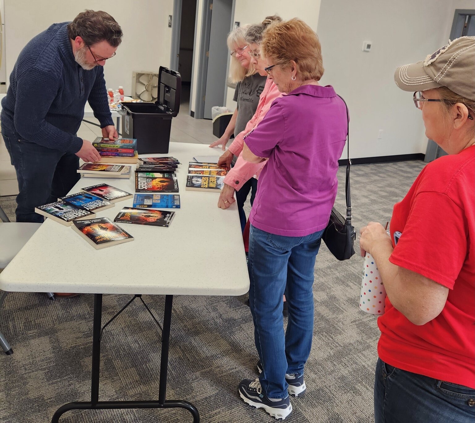 Craig A. Hart signing books for readers gathered around a display table
